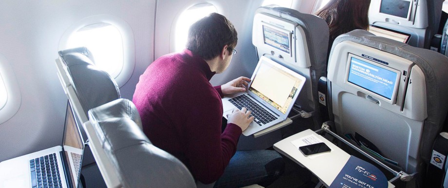 Journalists use their computers to test a new high speed inflight Internet service named Fli-Fi while on a special JetBlue media flight out of John F. Kennedy International Airport in New York