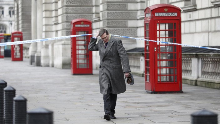 Conservative MP Dominc Grieve ducks under police tape on Whitehall the morning after an attack by a man driving a car and weilding a knife left five people dead and dozens injured, in London