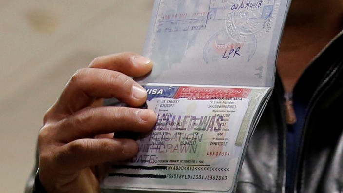 FILE PHOTO - A member of the Al Murisi family, Yemeni nationals who were denied entry into the U.S. last week because of the recent travel ban, shows the cancelled visa in their passport in Chantilly