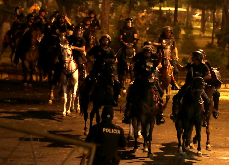 Police on horseback are seen during a demonstration against a possible change in law to allow for presidential re-election in front of the Congress building in Asuncion