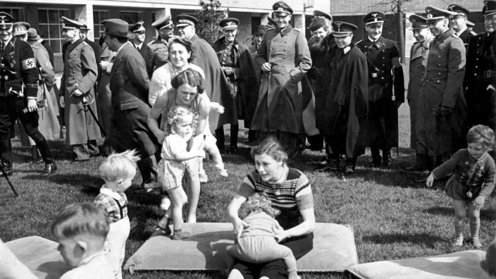 NSDAP-Funktionäre und Offiziere sehen mit Kleinkindern spielenden Frauen zu, 1939