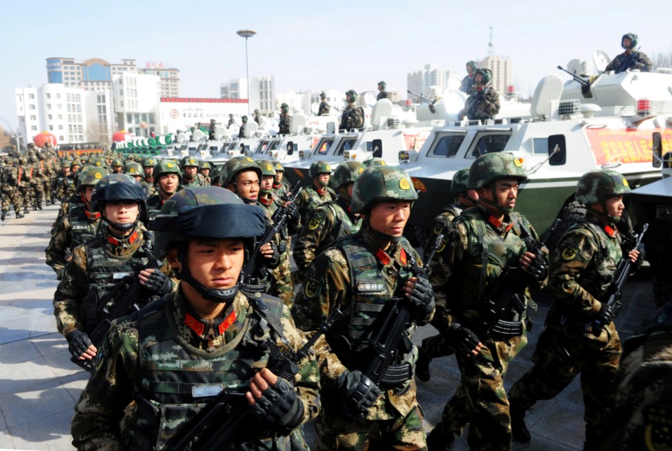 FILE PHOTO: Paramilitary policemen stand in formation as they take part in an anti-terrorism oath-taking rally, in Kashgar
