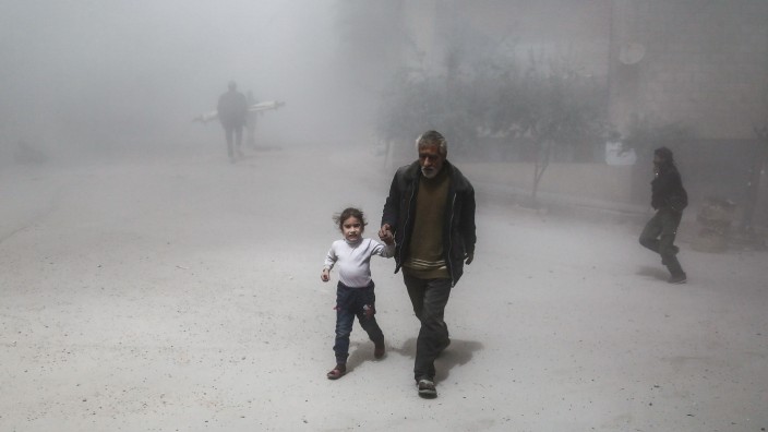Krieg in Syrien: Unter Beschuss: Zivilisten fliehen vor einem Luftangriff in einem Vorort der Hauptstadt Damaskus. Das Gebiet soll künftig kampffrei bleiben - doch Kritiker zweifeln an der Umsetzbarkeit des Abkommens.