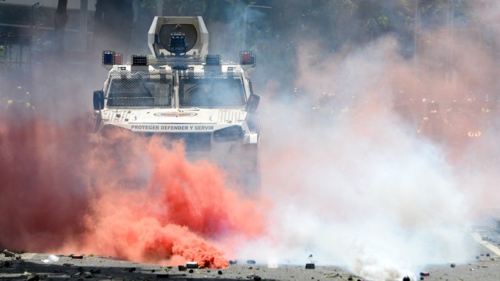 Venezuela: Roter Rauch wabert vor einem Polizeifahrzeug durch die Straßen von Caracas. Ein Oppositioneller warf der Regierung hier den Einsatz von Chemiewaffen vor.