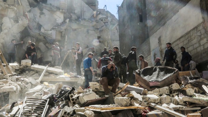 Völkerrecht: Suche nach Überlebenden nach einem Luftangriff in der von Rebellen gehaltenen Stadt Saqba.
