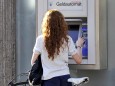 Frau mit Rennrad am Geldautomat