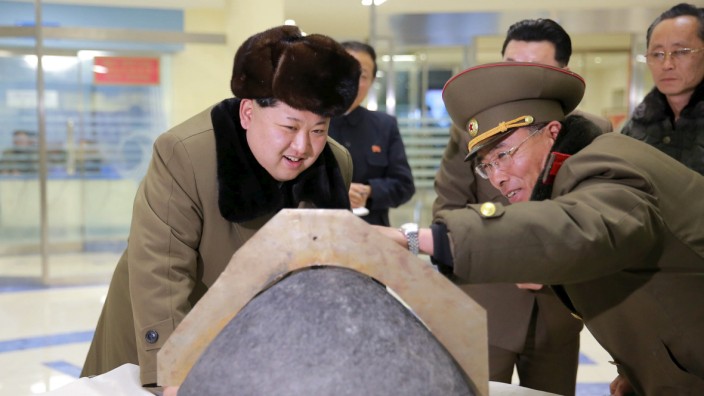 North Korean leader Kim Jong Un looks at a rocket warhead tip after a simulated test of atmospheric re-entry of a ballistic missile