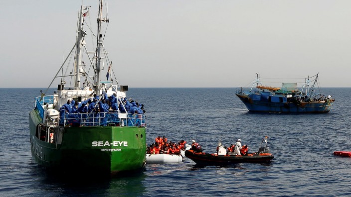 A Spanish military aircraft flies overhead as rescue NGOs Sea-Eye, Migrant Offshore Aid Station (MOAS) and Jugend Rettet Iuventa, and a Tunisian fishing boat carry out a joint rescue operation as some 20 migrants drowned in the central Mediterranean