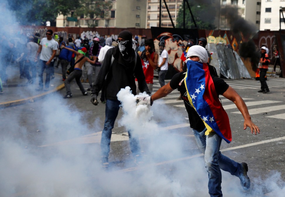 Opposition demonstrators clash with riot police during the so called 'mother of all marches' against Venezuela's President Nicolas Maduro in Caracas