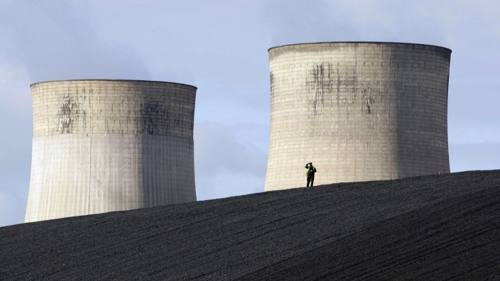 A security guard watches from a coal heap during a climate change protest at Ratcliffe Power Station at Ratcliffe-on-Soar