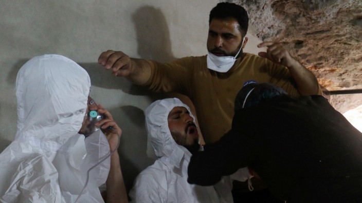 FILE PHOTO: A man breathes through an oxygen mask as another one receives treatments, after what rescue workers described as a suspected gas attack in the town of Khan Sheikhoun in rebel-held Idlib