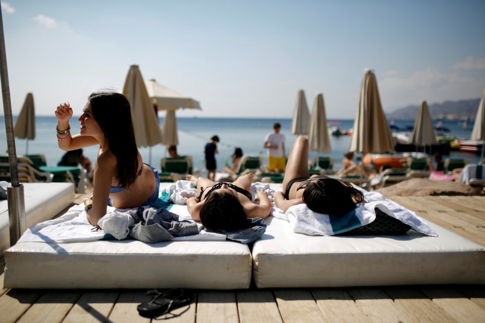 Tourists sunbathe on the beach in Eilat