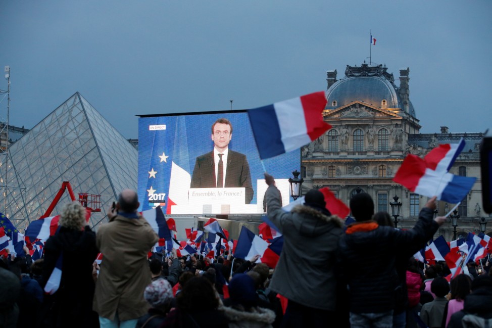 President Elect Emmanuel Macron is seen on a giant screen near the Louvre museum after results were announced in the second round vote of the 2017 French presidential elections