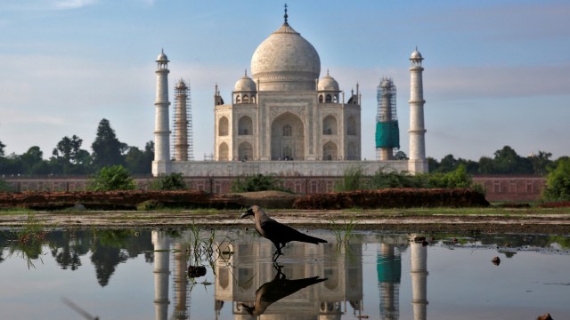 The Taj Mahal is reflected in a puddle in Agra