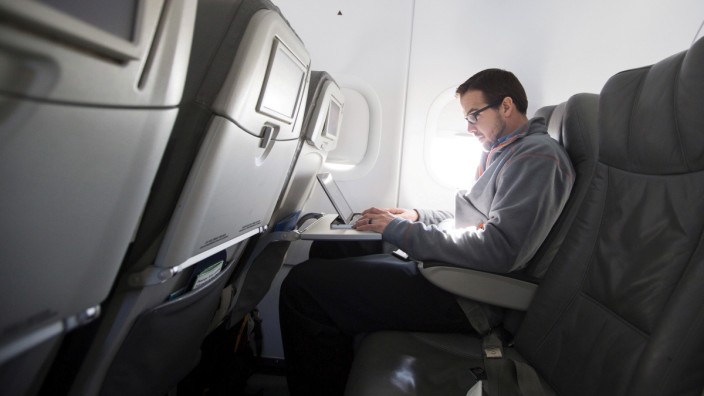 FILE PHOTO: A man uses his laptop to test a new high speed inflight Internet service named Fli-Fi while on a special JetBlue media flight out of John F. Kennedy International Airport in New York, file