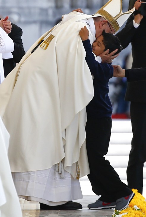 Pope Francis greets a child as he leads the Holy Mass at the Shrine of Our Lady of Fatima in Portugal