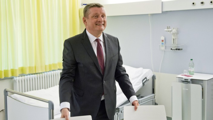 Hermann Groehe CDU Bundesminister fuer Gesundheit steht in einem Krankenzimmer waehrend dem Besu