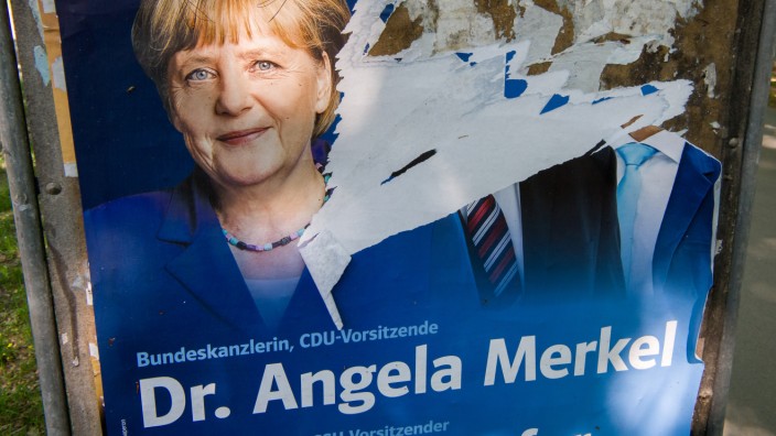 Abgerissenes Wahlplakat mit Angela Merkel