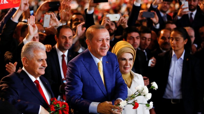 Turkish President Tayyip Erdogan, accompanied by his wife Emine Erdogan and Prime Minister Binali Yildirim, greets members of his party during the Extraordinary Congress of the ruling AKP in Ankara