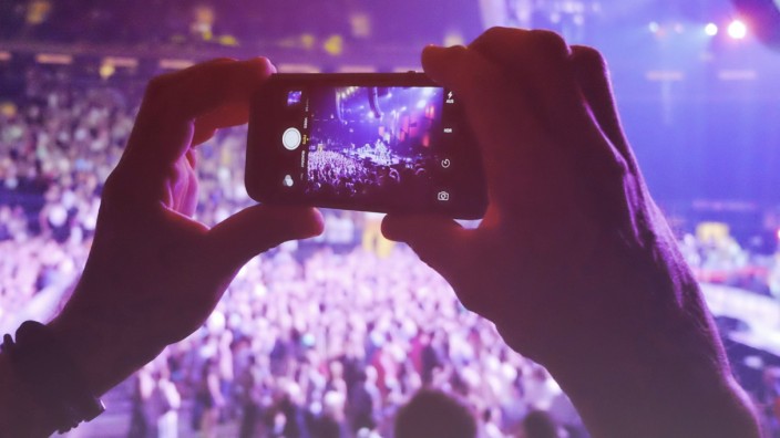 Hands holding smart phone filming concert model released Symbolfoto PUBLICATIONxINxGERxSUIxAUTxHUNx