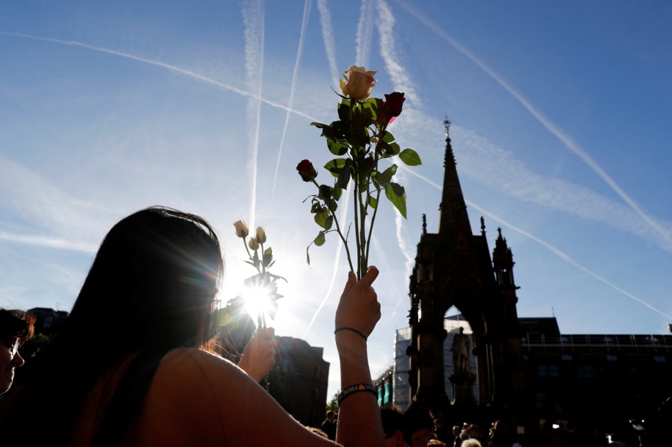 A woman holds flowers as she takes part in a vigil for the victims of an attack on concert goers at Manchester Arena, in central Manchester