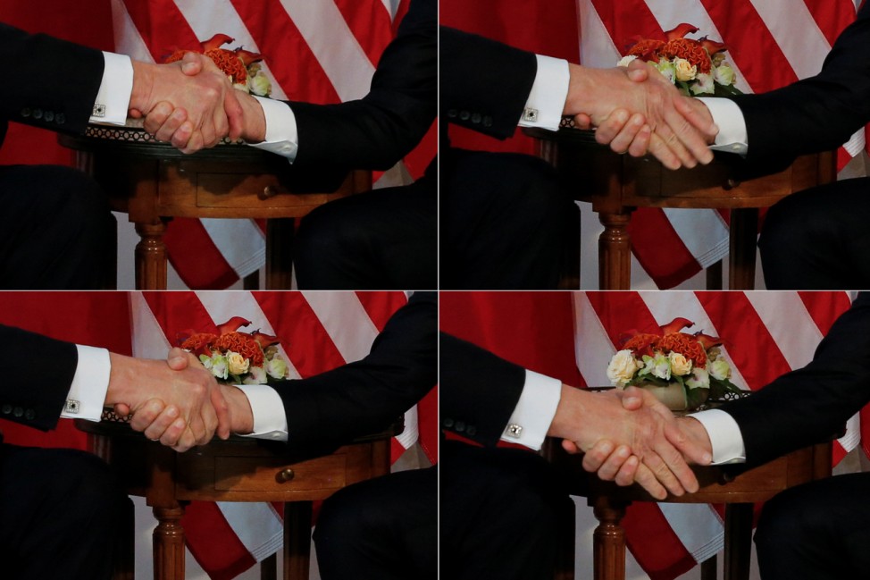 A combination photo shows U.S. President Trump  trying twice to let go of a handshake with France's President Macron as Macron holds tight, before a working lunch ahead of a NATO Summit in Brussels