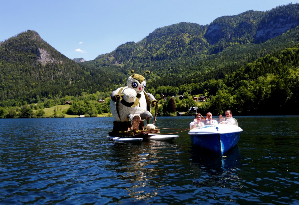 A float decorated with a figure made of daffodil blossoms participates in a parade during the daffodil festival on Grundlsee lake in Grundlsee