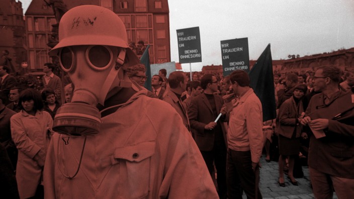 A demonstrator wearing a military gas mask and helmet...