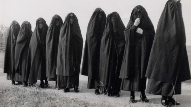Trauerzug zu Beginn des 20. Jahrhunderts. Die Damen tragen den sogenannten "Huik", einen schwarzen Ganzkörperschleier, der sich im 17. Jahrhundert in den Niederlanden und in Belgien eingebürgert hat.