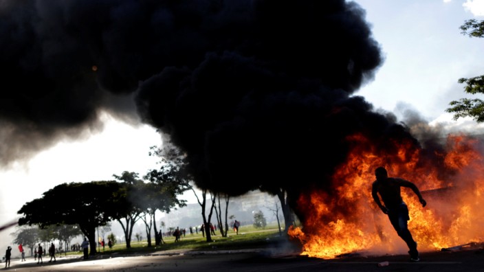 A demonstrator runs near a burning barricade during a protest against President Michel Temer and the latest corruption scandal to hit the country, in Brasilia