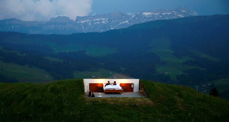 Raphael and Mirjam pose as first guests in the bedroom of the Null-Stern-Hotel land art installation by Swiss artists Frank and Patrik Riklin near Gonten