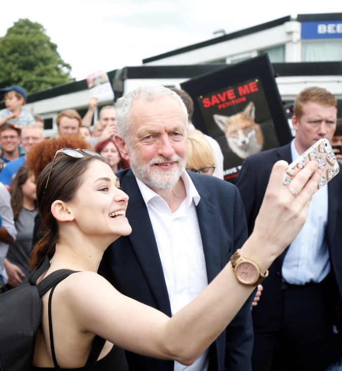 Leader of Britain's opposition Labour Party Corbyn poses for a selfie as he campaigns in Manchester