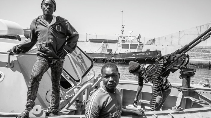 Flüchtlinge in Libyen: Kugeln gegen Schleuser: Die Männer von Commander Al Bija bereiten sich im Hafen von Zawiya auf eine Nachtpatrouille vor.