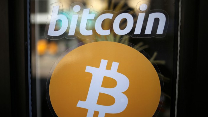 A sign is seen outside a business where a Bitcoin ATM is located in Toronto