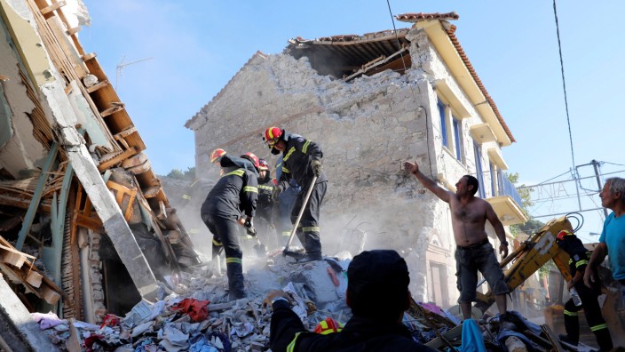 Rescue team members search for victims at a collapsed building in the village of Vrissa on the Greek island of Lesbos
