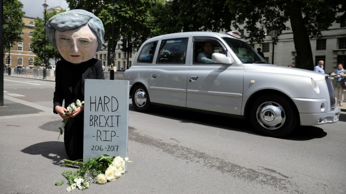 FILE PHOTO: A protestor wears a Theresa May mask