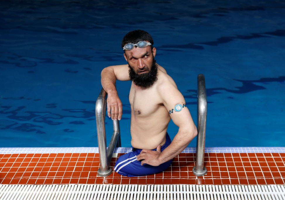 Khan Agha 28, sits in a swimming pool during his practice in Kabul