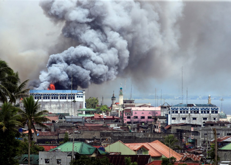 Black smoke comes from a burning building in a commercial area of Osmena street in Marawi city