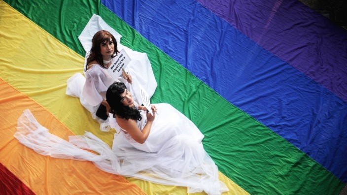 Homo-Ehe: In einigen Ländern dürfen sie heiraten, in Deutschland nicht. Zwei Bräute auf einer Regenbogenfahne.