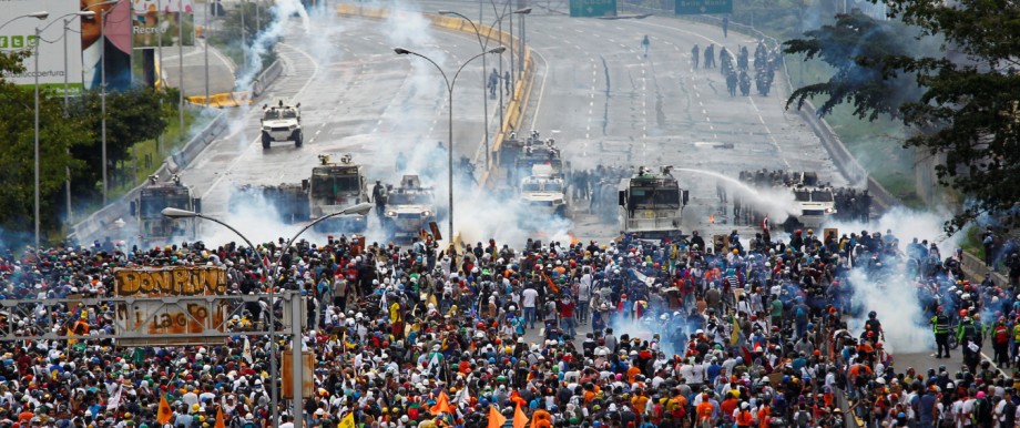 Demonstrators clash with riot security forces while rallying against Venezuela's President Maduro's government in Caracas