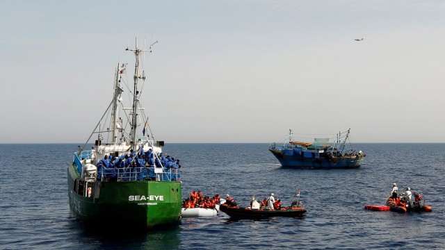 A Spanish military aircraft flies overhead as rescue NGOs Sea-Eye, Migrant Offshore Aid Station (MOAS) and Jugend Rettet Iuventa, and a Tunisian fishing boat carry out a joint rescue operation as some 20 migrants drowned in the central Mediterranean