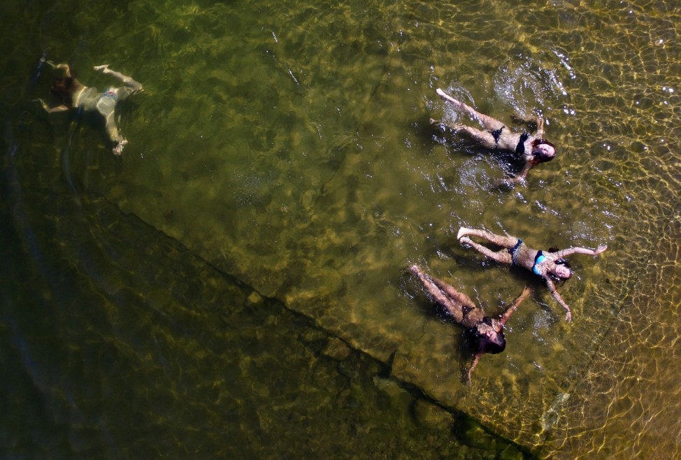 An aerial view shows women swimming in the Yenisei River on a hot summer day outside Krasnoyarsk