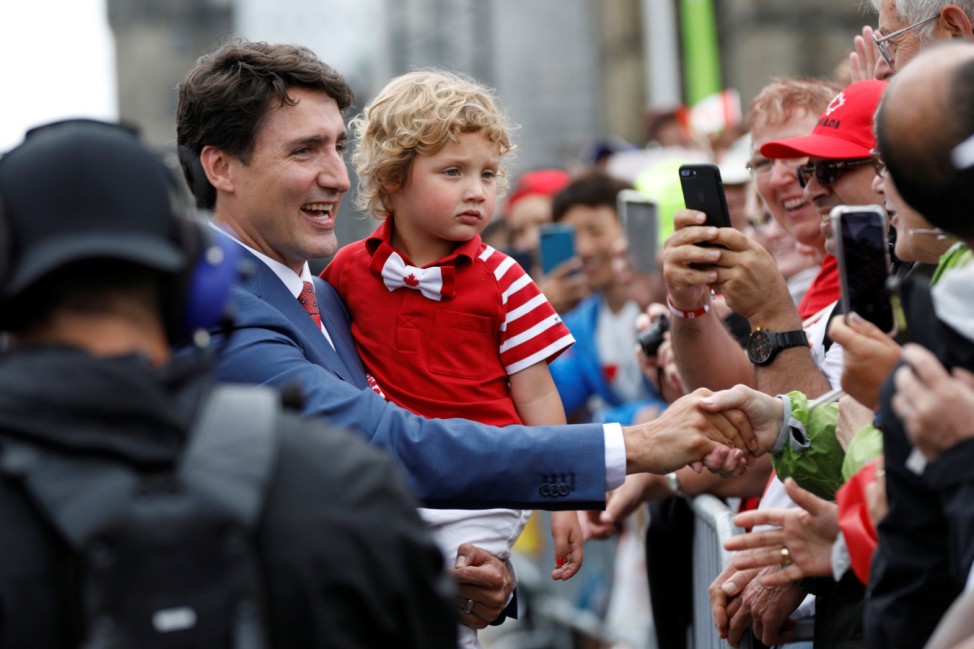 Canada's PM Trudeau, holding his son Hadrien, arrives with his family on Parliament Hill during Canada Day celebrations as the country marks its 150th anniversary since confederation, in Ottawa