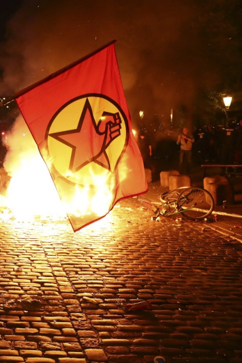 Protesters stand near a burning barricade during the demonstration during the G20 summit in Hamburg