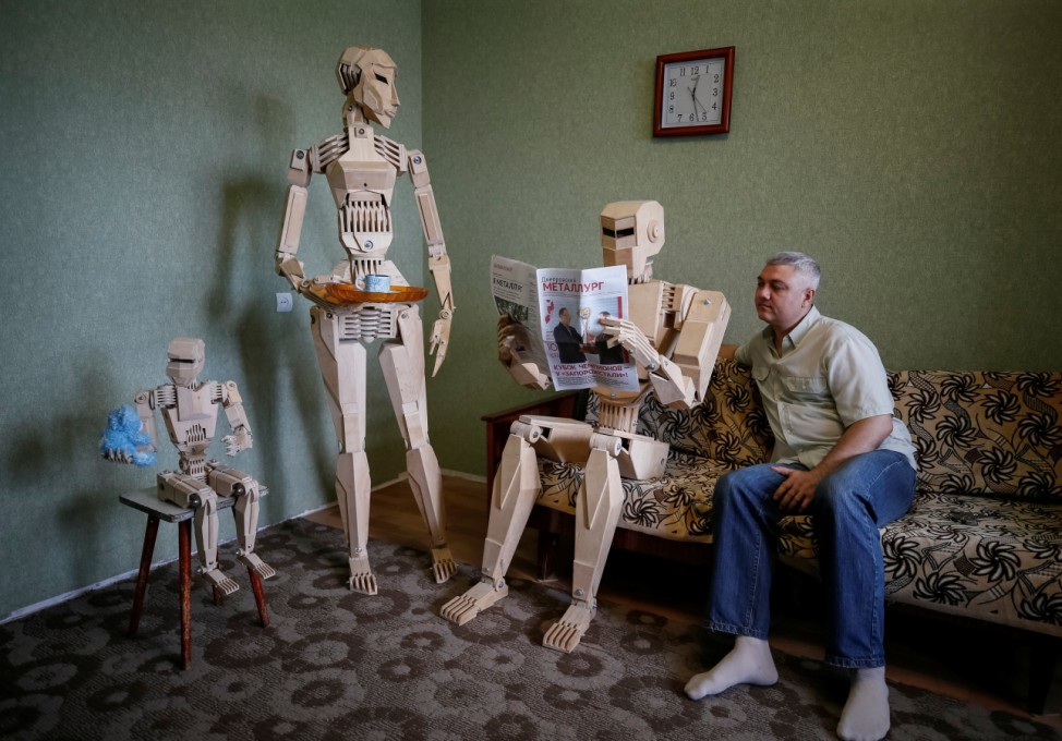 Balandin poses with his wooden models in his flat in Zaporizhzhya
