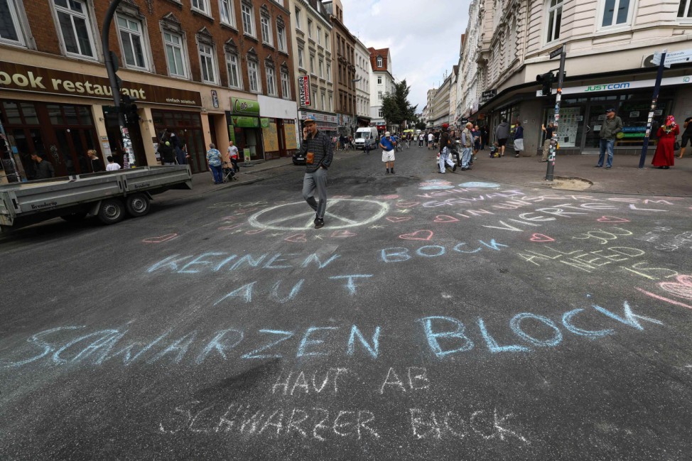 A man walks past the sign on the street after demonstrations at the G20 summit in Hamburg