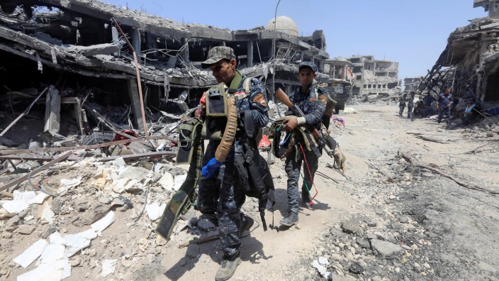 Members of Iraqi Federal police carry suicide belts used by Islamic State militants in the Old City of Mosul