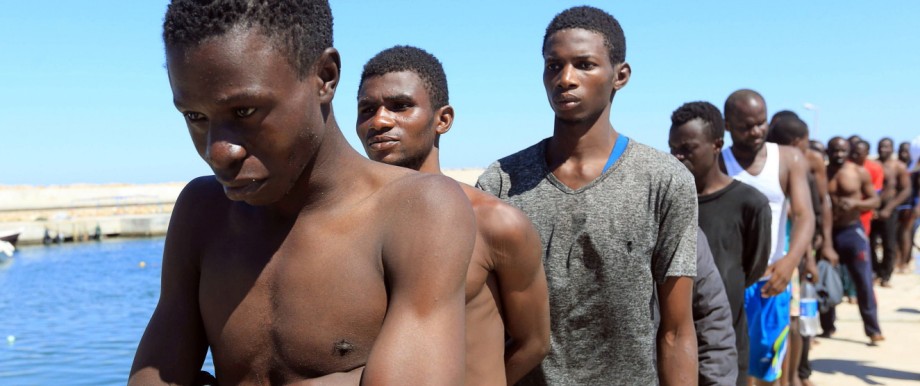 Flüchtlinge: Von der libyschen Küstenwache gerettete afrikanische Migranten, deren Schlauchboot noch an der libyschen Küste sank, laufen in Richtung eines Lagers rund 60 Kilometer östlich von Tripolis entfernt.