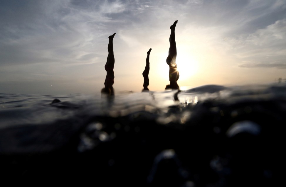People practise standup paddleboard yoga, or SUP yoga, on the Adriatic coast in Verudela