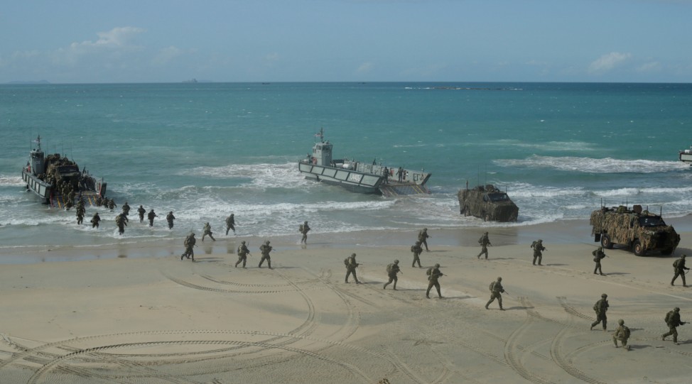 Soldiers from the Australian Army's 3rd Brigade march across Langham Beach after an amphibious assault landing during the Talisman Saber joint military exercises